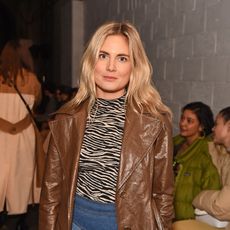 Lucy Williams in a stripe top and brown leather coat