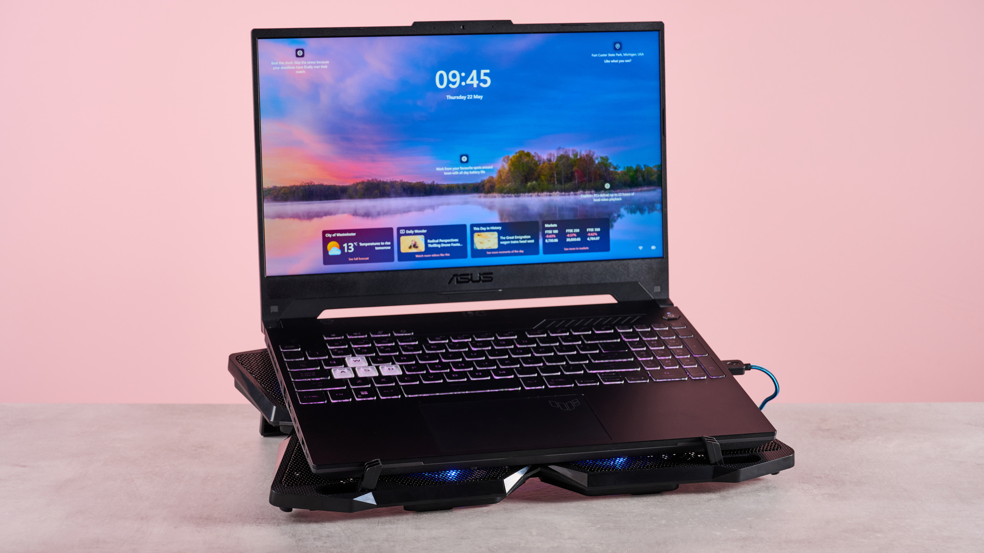 The Klim Wind with an open Acer Predator Helios 300 sat on top of it in front of a pink background.