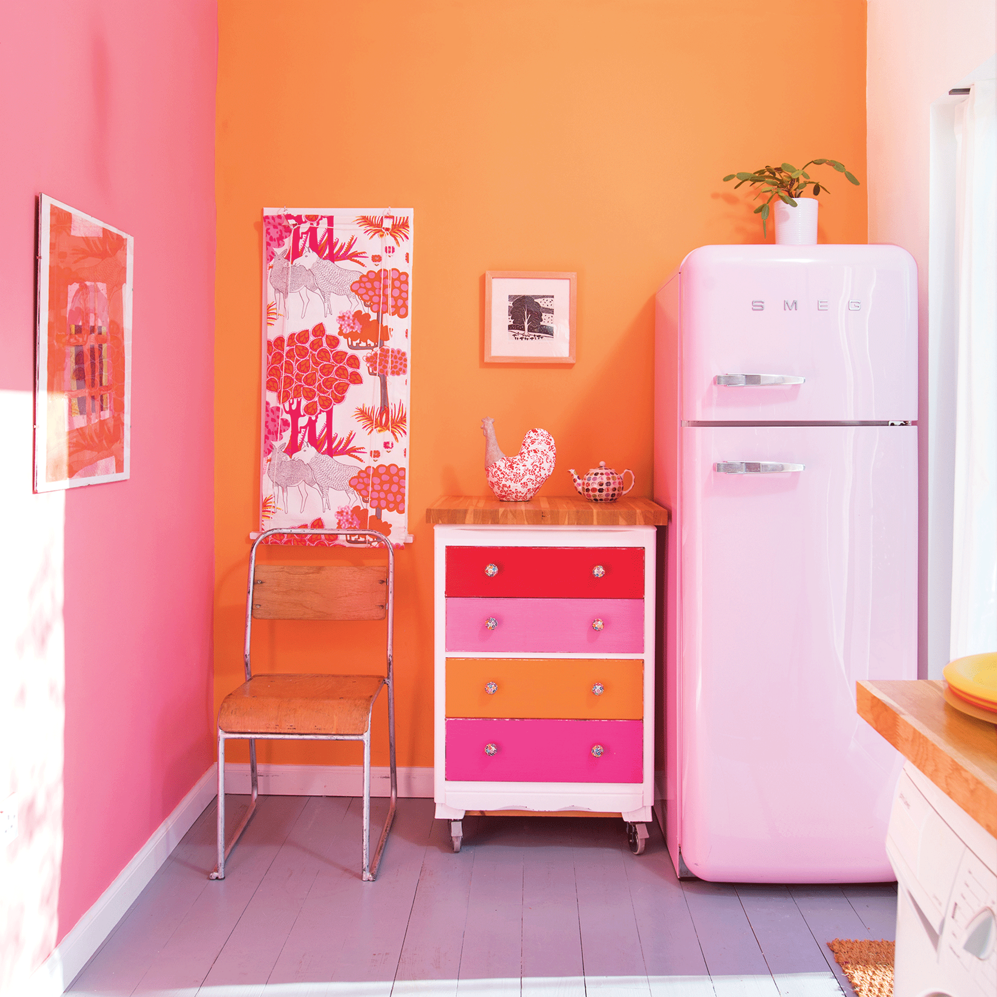 Pink and orange kitchen with pink smeg fridge