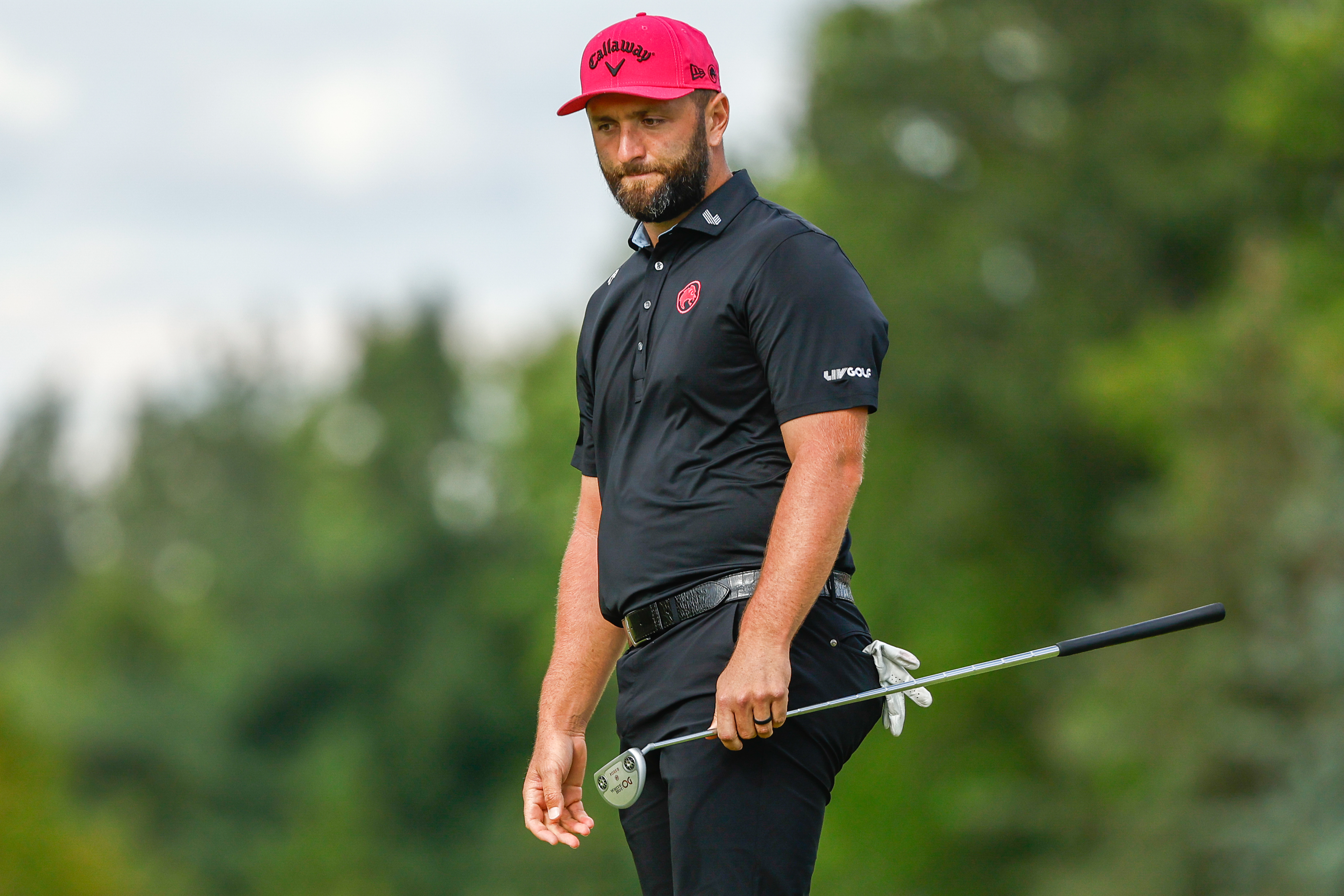 Jon Rahm strikes a putt and looks down