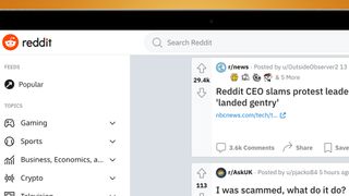 A laptop screen on an orange blackout showing Reddit posts about the blackout