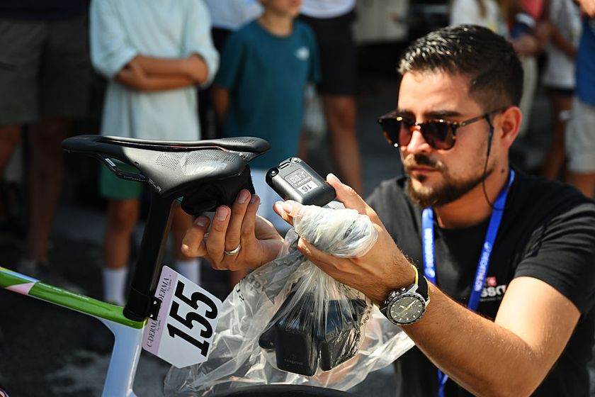 LA TZOUMAZ, SWITZERLAND - AUGUST 16: A technician from the International Cycling Union (UCI) checks the GPS security tracker during the 4th Tour de Romandie Feminin 2025, Stage 2 a 123.2km stage from Conthey to La Tzoumaz 1522m / #UCIWWT / on August 16, 2025 in La Tzoumaz, Switzerland. (Photo by Dario Belingheri/Getty Images)