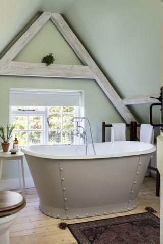 Green bathroom, reposed wooden beams in A shape, grey bath