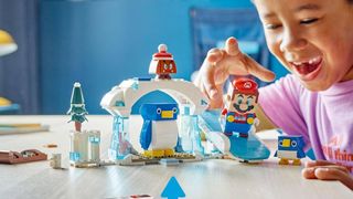 Kid playing with Super Mario Penguin Family Lego set