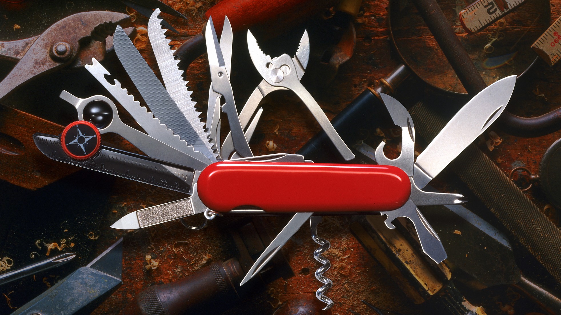 A red "Swiss Army" knife with the tools extended. Image modified for 16:9 ratio.