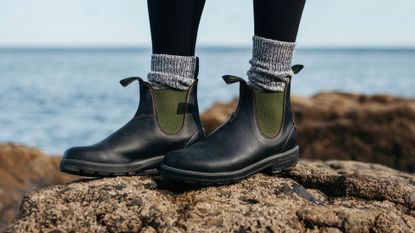 Person wearing Finisterre x Blundstone vegan boots on the beach