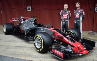 HAAS F1 Team's Danish driver Kevin Magnussen (L) and HAAS F1 Team's French driver Romain Grosjean pose by their new VF17 car during their official presentation at the Circuit de Catalunya on