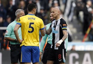 Brighton and Hove Albion captain Lewis Dunk and Newcastle United captain Jonjo Shelvey shake hands whilst wearing their yellow and blue captains armbands to show support for Ukraine during the Premier League match at St. James’ Park, Newcastle upon Tyne. Picture date: Saturday March 5, 2022