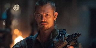 Rick Flag (Joel Kinnaman) holds a gun and stands in front of a fire in 'Suicide Squad'