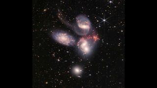 A cluster of galaxies in Stephan's Quintet can be seen in deep space.