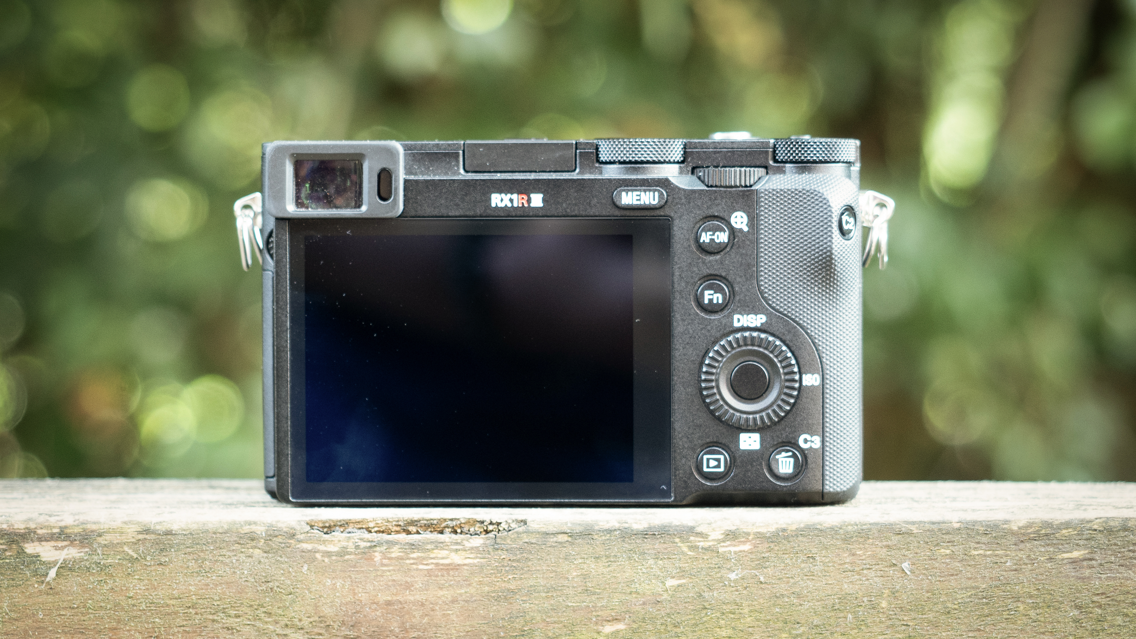 Sony RX1R III on a wooden surface in a woodland environment