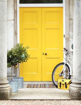 yellow front door with bag and bicycle