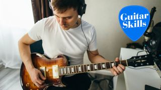 Man playing guitar while wearing headphones