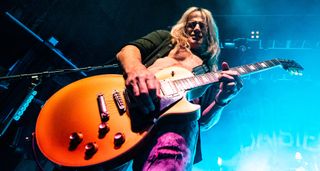 Pictured from below, Doug Aldrich of the Dead Daisies plays his Gold Top Les Paul onstage.