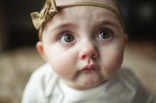 Baby crying with headband on
