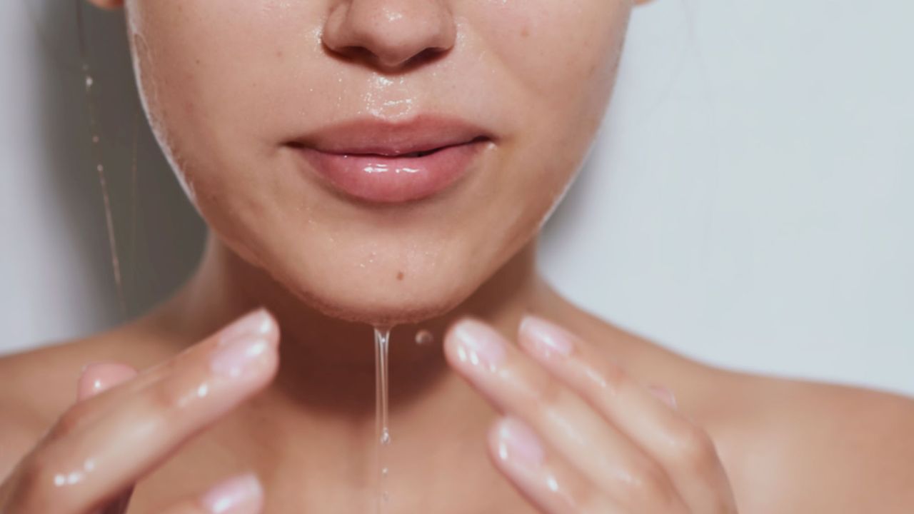 Woman washing face with water