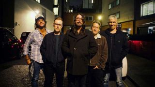 Foo Fighters standing together outside at night