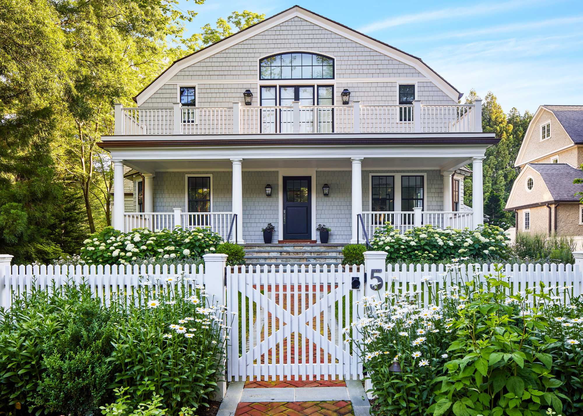 a beautiful, traditional front yard home with double hedges