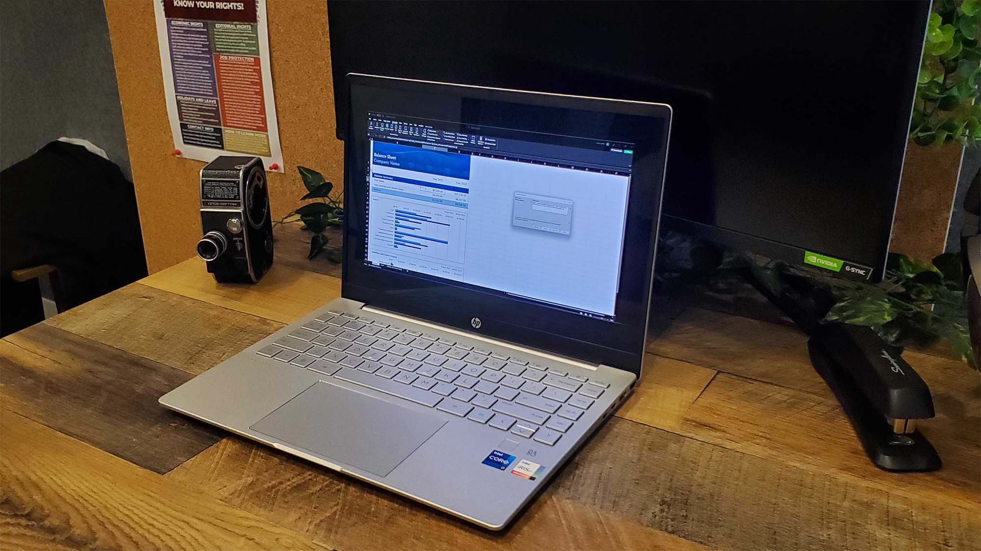 An HP Pavilion Plus 14 on a desk with a spreadsheet on its screen