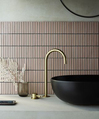 Japandi inspired sink detail with brushed brass tap, black bowl sink and textured blush pink wall tiles