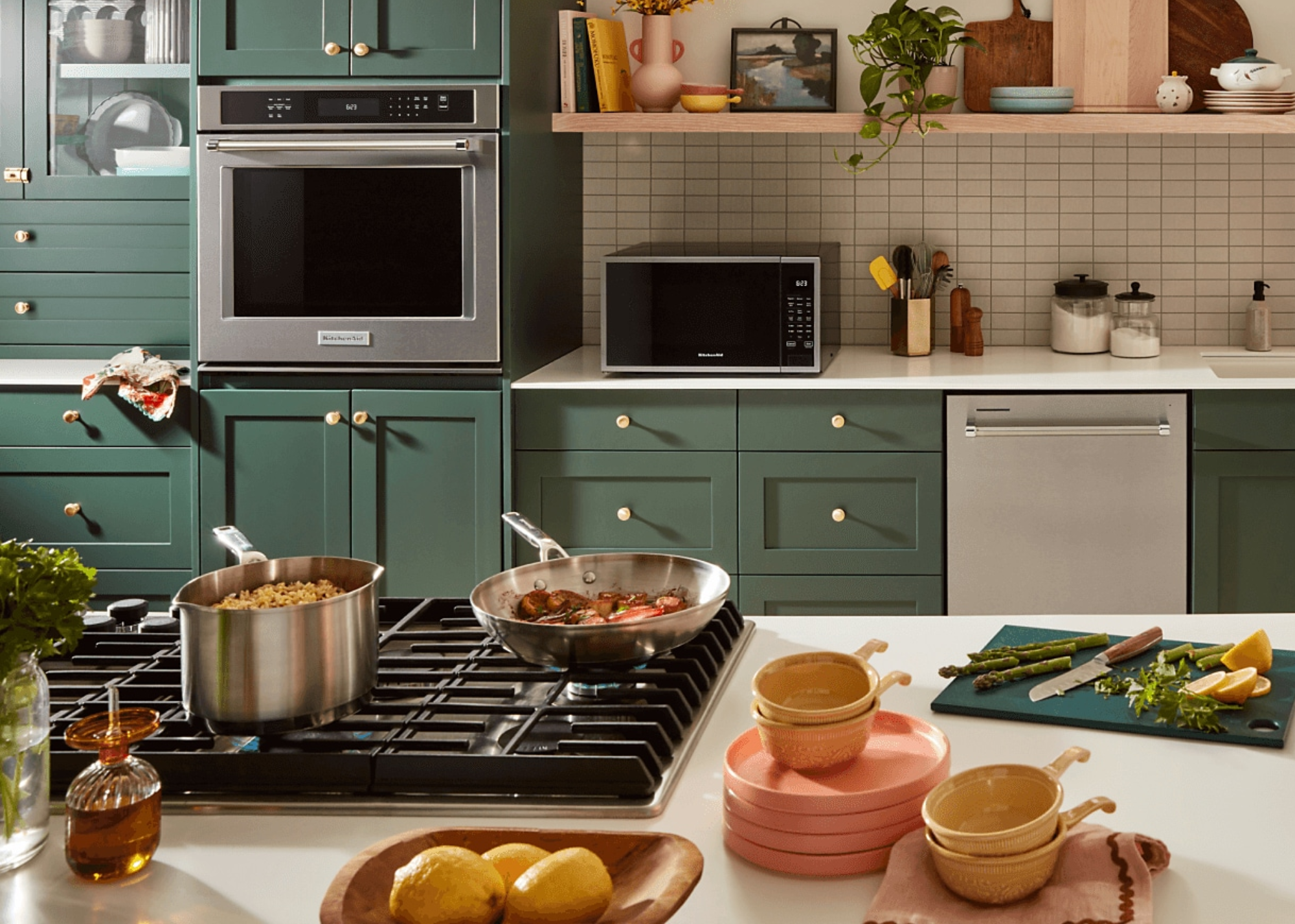 A green kitchen with KitchenAid pots, pans and cooking ingredients