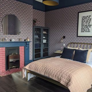 bedroom with pink and navy patterned wallpaper and fireplace