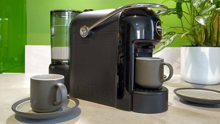 Lavazza Jolie Evo coffee maker on kitchen counter with espresso cups and saucers