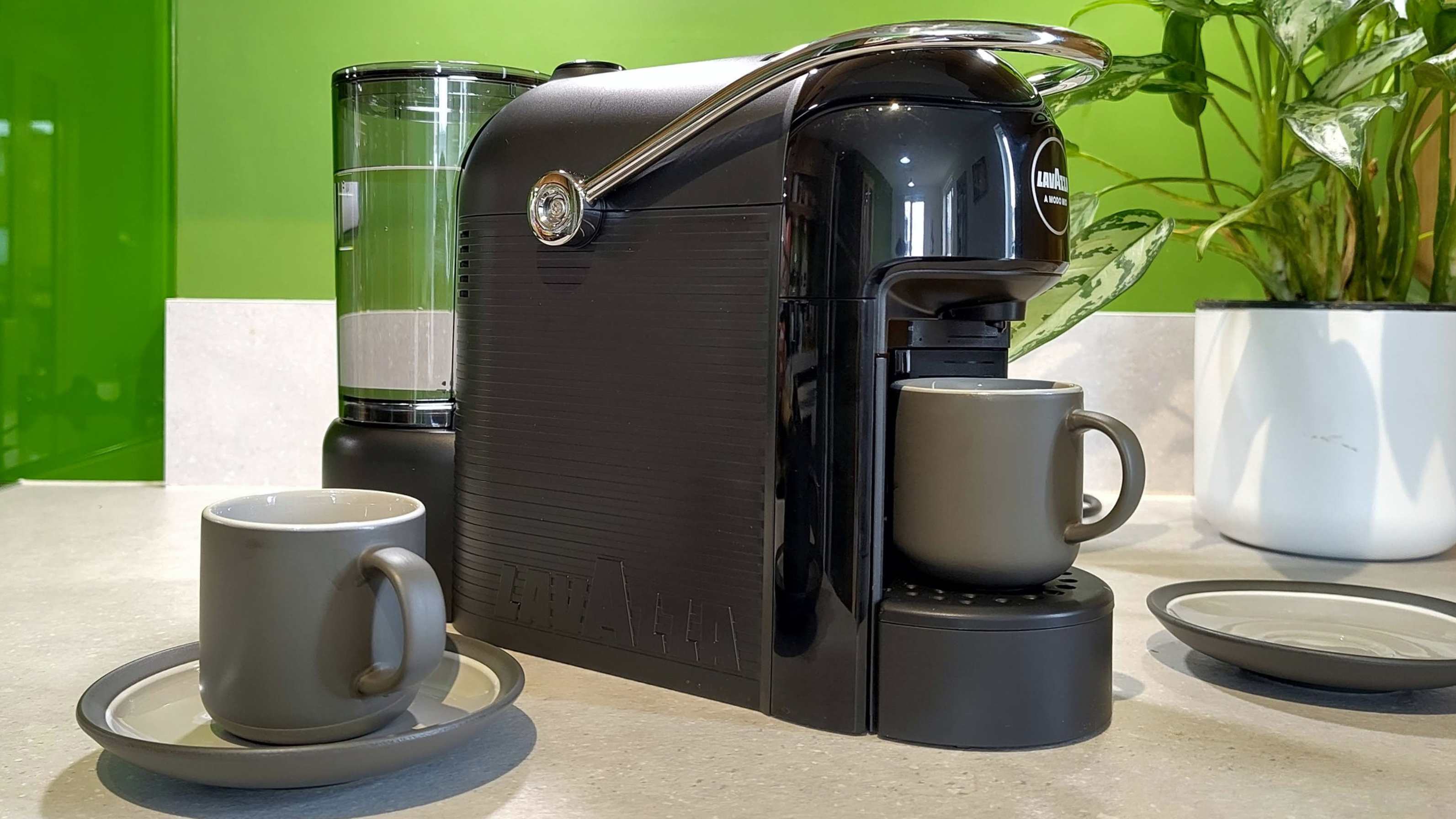 Lavazza Jolie Evo coffee maker on kitchen counter with espresso cups and saucers