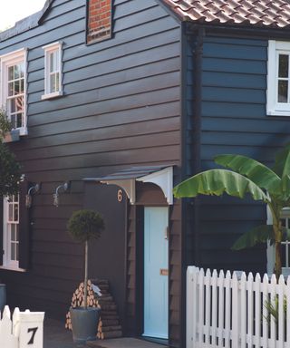 Black panelled house with pale blue door