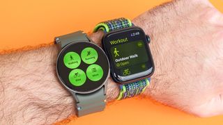 Close up of a Samsung Galaxy Watch 7 and Apple Watch SE 2022 on a user's wrist with the fitness app opened on each 