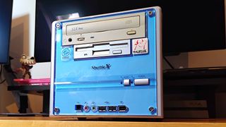 Shuttle XPC from 2001 at an angle with blue front plate sitting on woodgrain surface.
