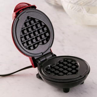 An open waffle maker with heart-shaped iron