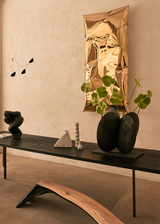 A black planter with anthuriums on a black table