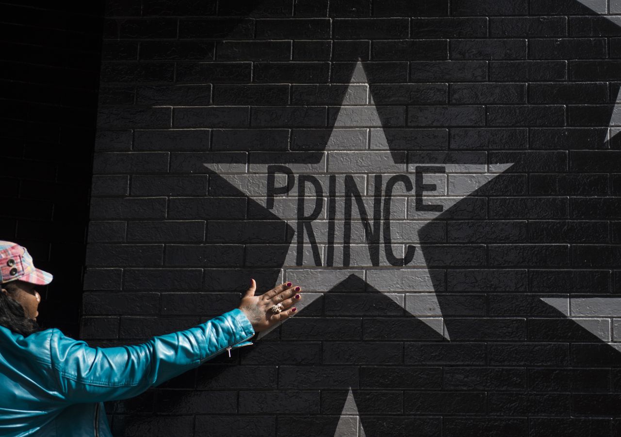 MINNEAPOLIS, MN - APRIL 21: A woman touches the Prince star on the wall outside the First Avenue nightclub on April 21, 2016 in Minneapolis, Minnesota. Prince died earlier today at his Paisle
