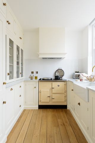 Galley kitchen with range and white cabinets