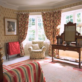 room with floral curtains and armchair
