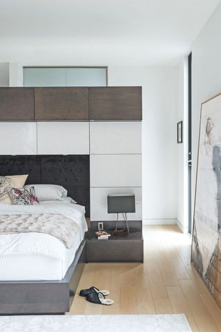 a bedroom with a room divider as a headboard