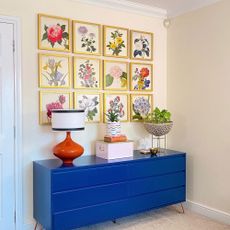 Floral gallery wall above blue sideboard