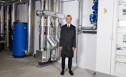 A man in black suit in a factory.