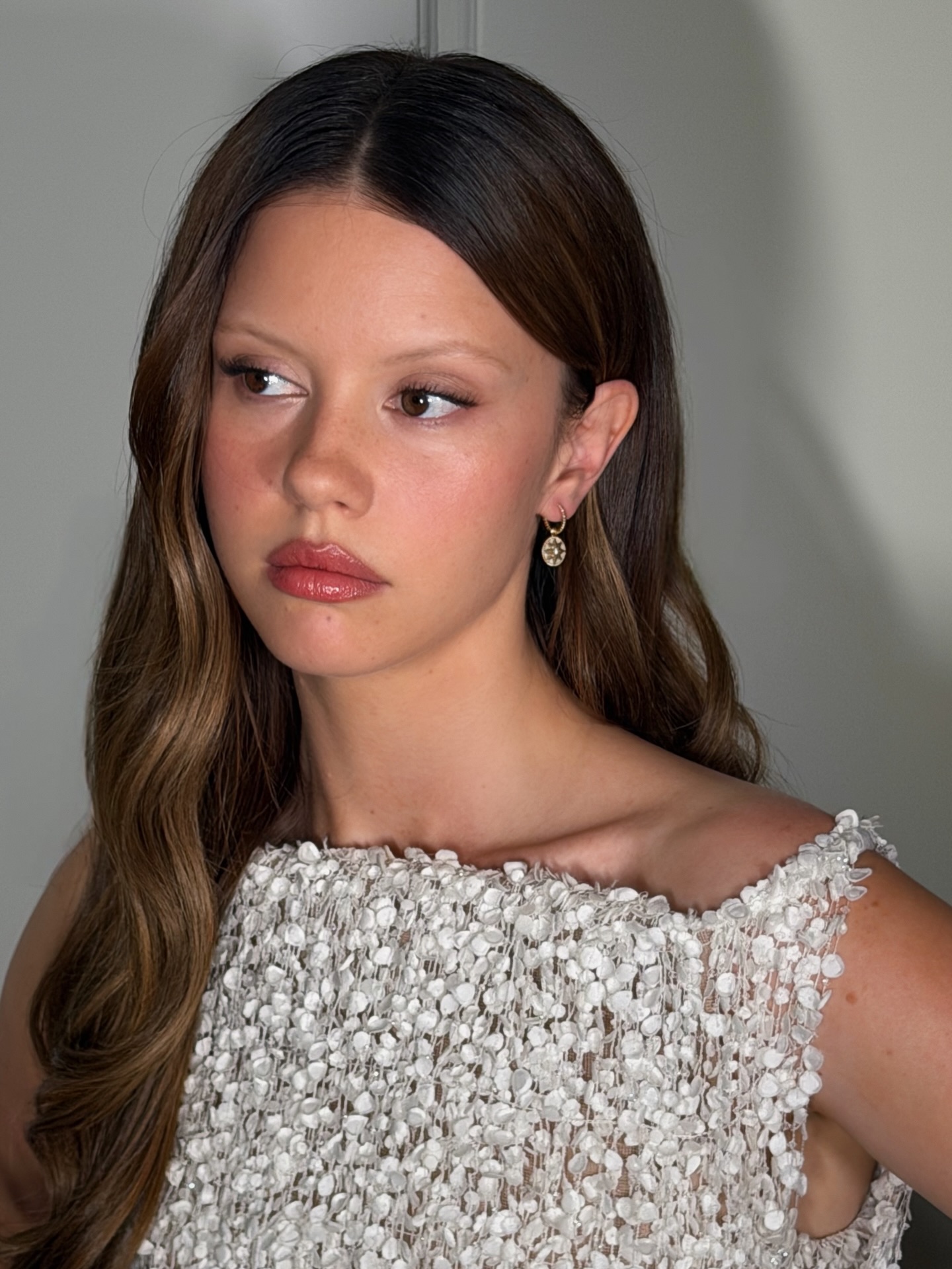 Mia Goth with long centre-parted hair and glossy lip - best lip balm for dry lips