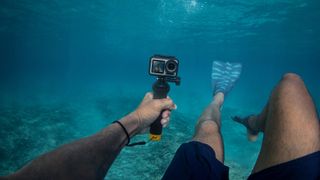 GoPro Hero 8 Black vs DJI Osmo Action: a man films himself swimming underwater with the DJI Osmo Action camera