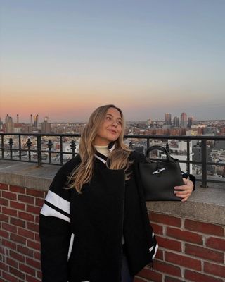 @oliviamarcus wears a varsity bomber jacket