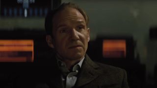 Ralph Fiennes sitting in a dark room with servers in Spectre.