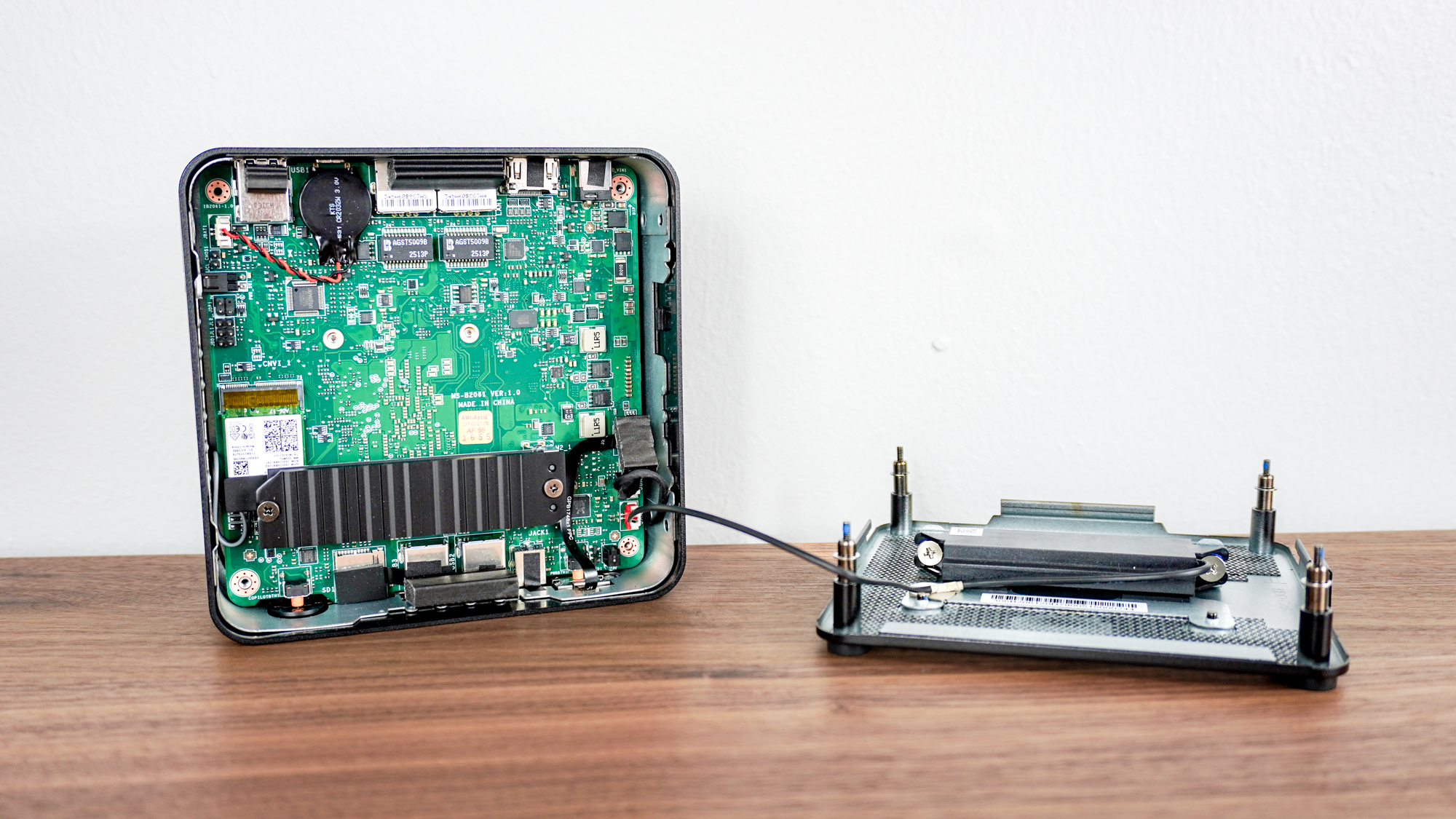 The MSI Cubi NUC AI+ 2MG open on a table showing its motherboard, SSD and soldered memory