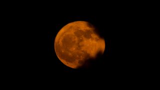 An orange and pink hued Strawberry Full Moon over Charlotte, North Carolina seen by Kevin McCarthy.