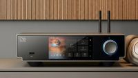 The Shanling SM90 streamer on a grey surface in front of a wood-panelled wall.