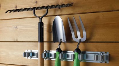 Garden tool holder storing tools in shed