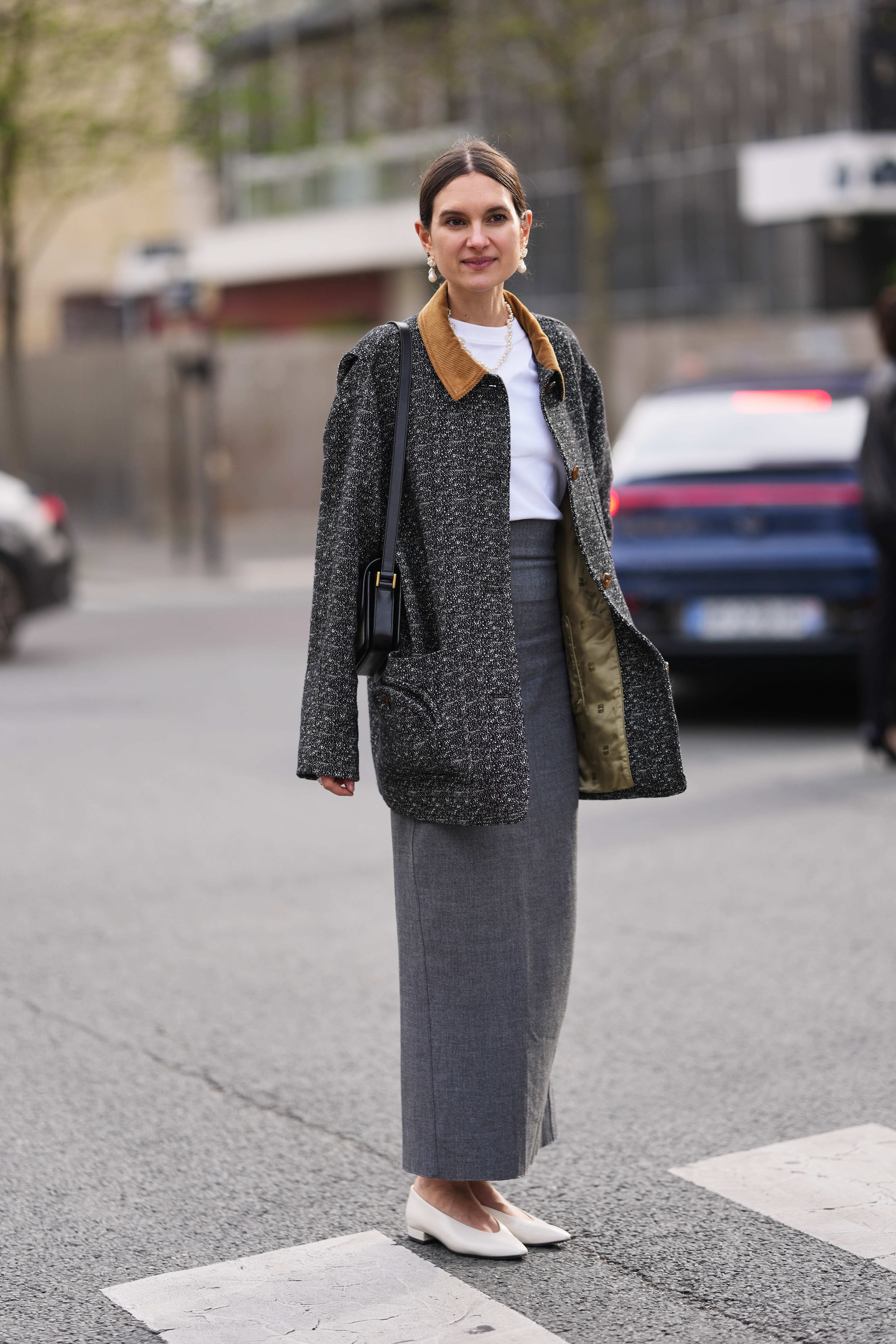 woman wears white ballet flats, grey pencil skirt and tshirt to paris fashion week