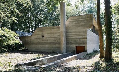 Concrete house in geometric form with chimney