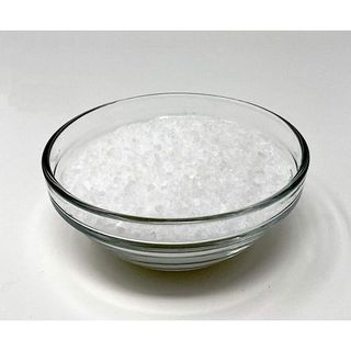 A clear glass bowl of sea salt